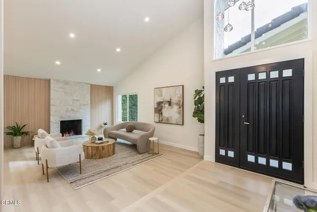 a living room with furniture a fireplace and a floor to ceiling window