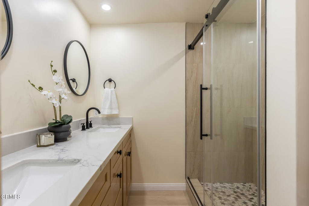 11772 Monte Leon Way Porter Ranch, CA 91326 - Photo 43 of 58 a bathroom with a granite countertop sink a mirror and a shower