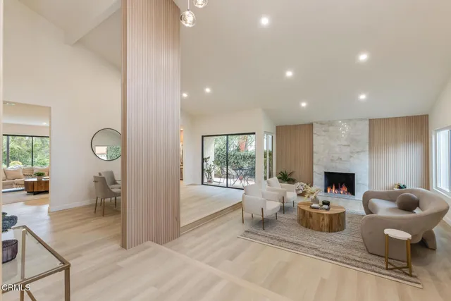 a living room with furniture a fireplace and a floor to ceiling window