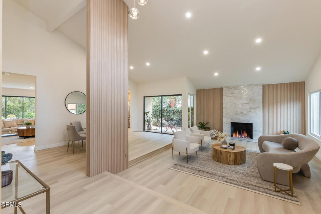 11772 Monte Leon Way Porter Ranch, CA 91326 - Photo 5 of 58 a living room with furniture a fireplace and a floor to ceiling window