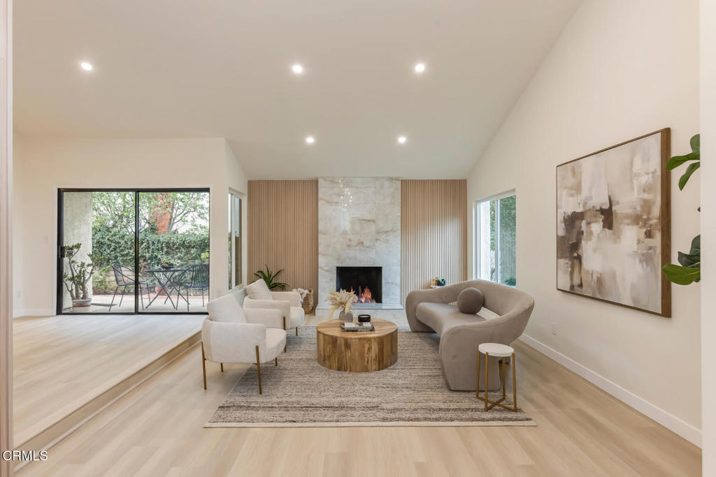 11772 Monte Leon Way Porter Ranch, CA 91326 - Photo 6 of 58 a living room with furniture a fireplace and a floor to ceiling window