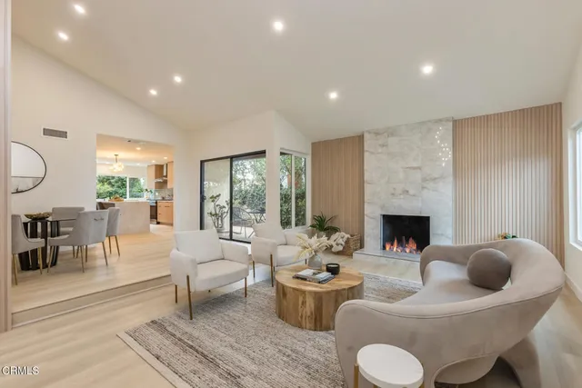 a living room with furniture potted plant and large windows