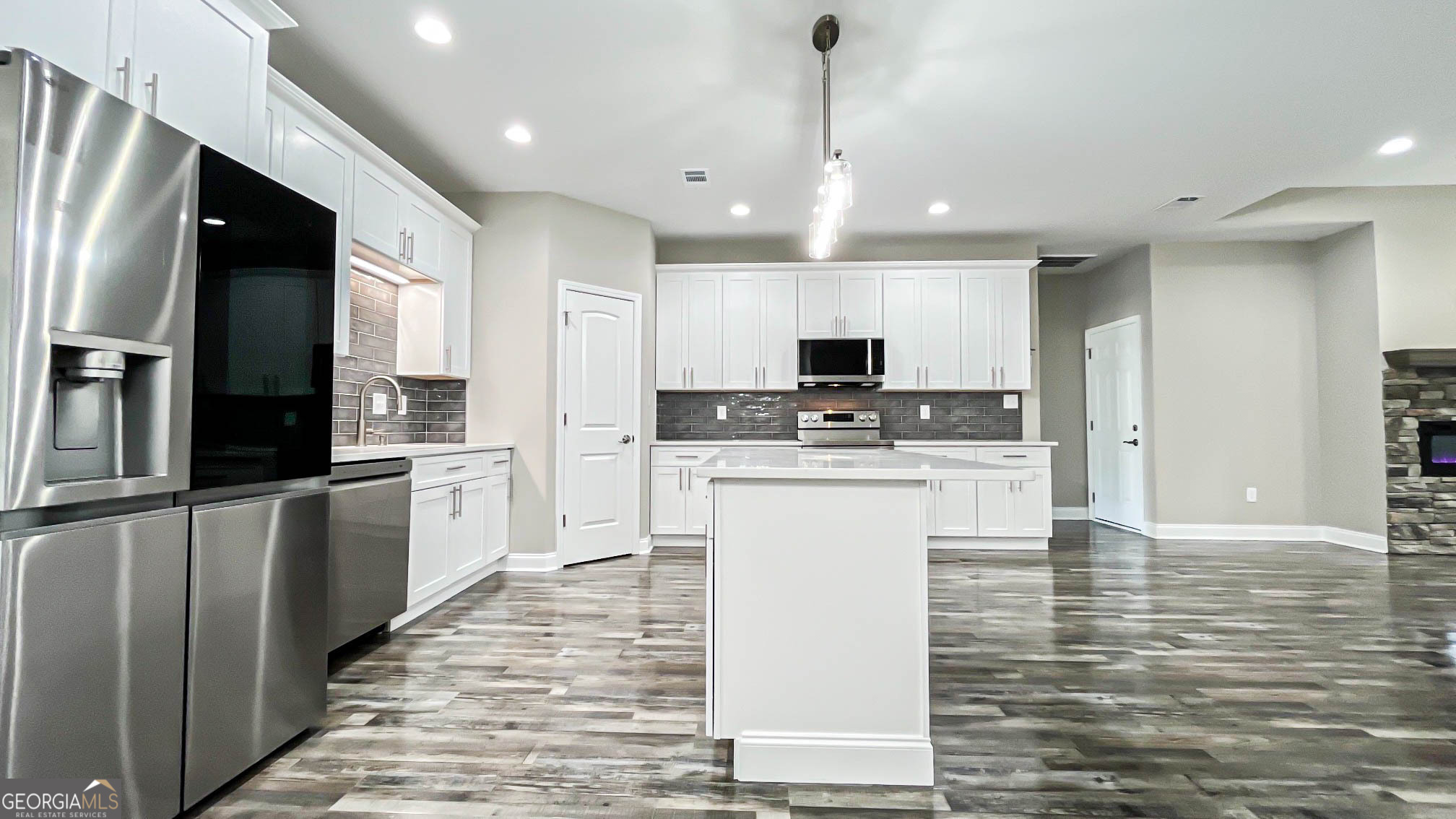 2011 Griffin Road Macon, GA 31216 - Photo 17 of 64 a kitchen with stainless steel appliances kitchen island granite countertop a refrigerator a stove and white cabinets with wooden floor