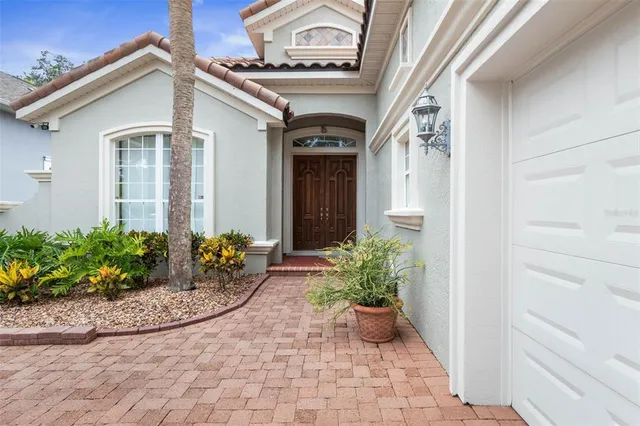 a bedroom with a bed next to a window with a chandelier