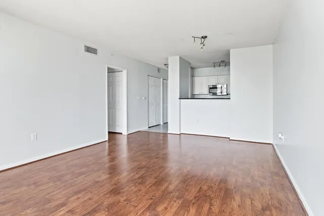 a view of a hardwood floor in a room with a kitchen