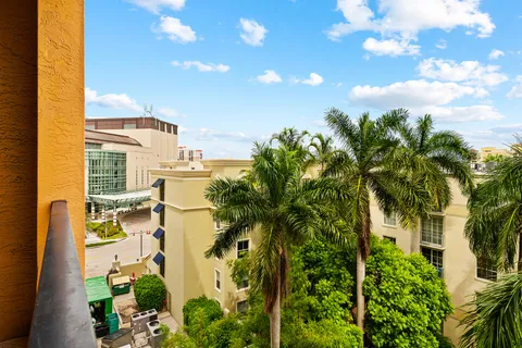 a view of a multi story residential apartment building with a yard