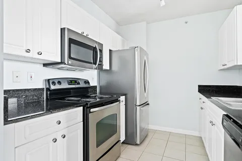 a kitchen with stainless steel appliances white cabinets and a stove
