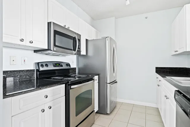 a kitchen with stainless steel appliances white cabinets and a stove