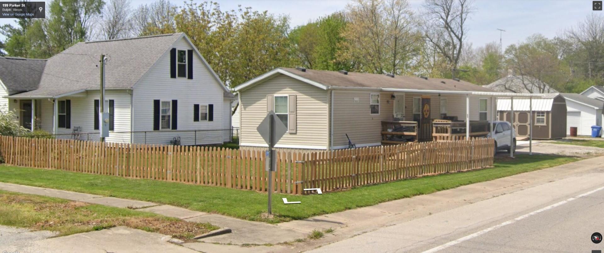 225 Parker Street Bulpitt, IL 62517 - Photo 2 of 12 a view of a white house with a small yard and large trees