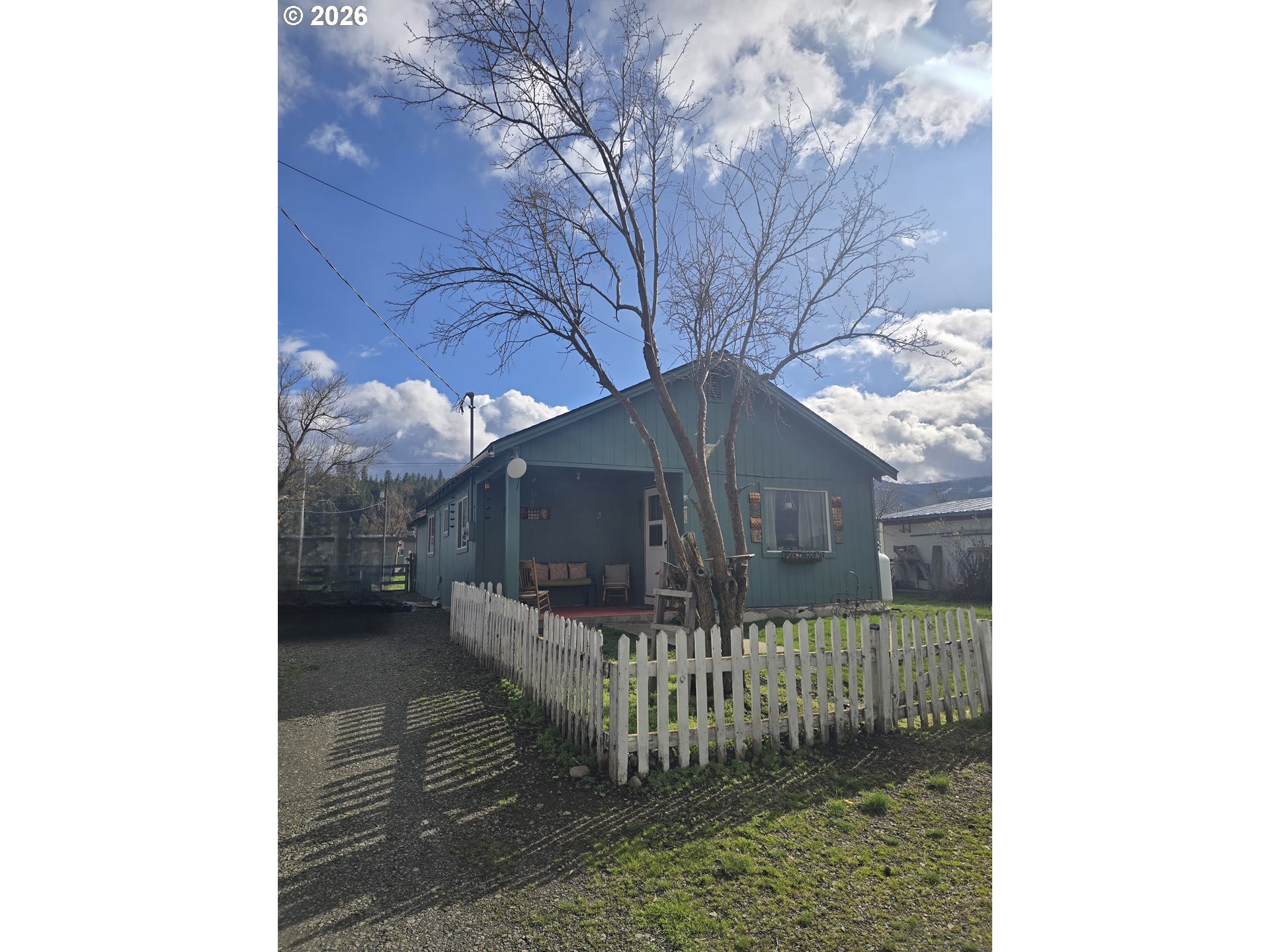 302 West 3rd Street Wallowa, OR 97885 - Photo 1 of 10 a view of a house with a small yard and wooden fence