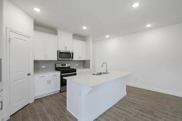 a kitchen with a sink stainless steel appliances and white cabinets