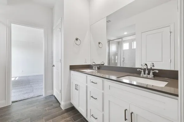 a bathroom with double sink and a mirror