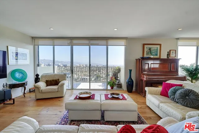 a living room with furniture a flat screen tv and a large window