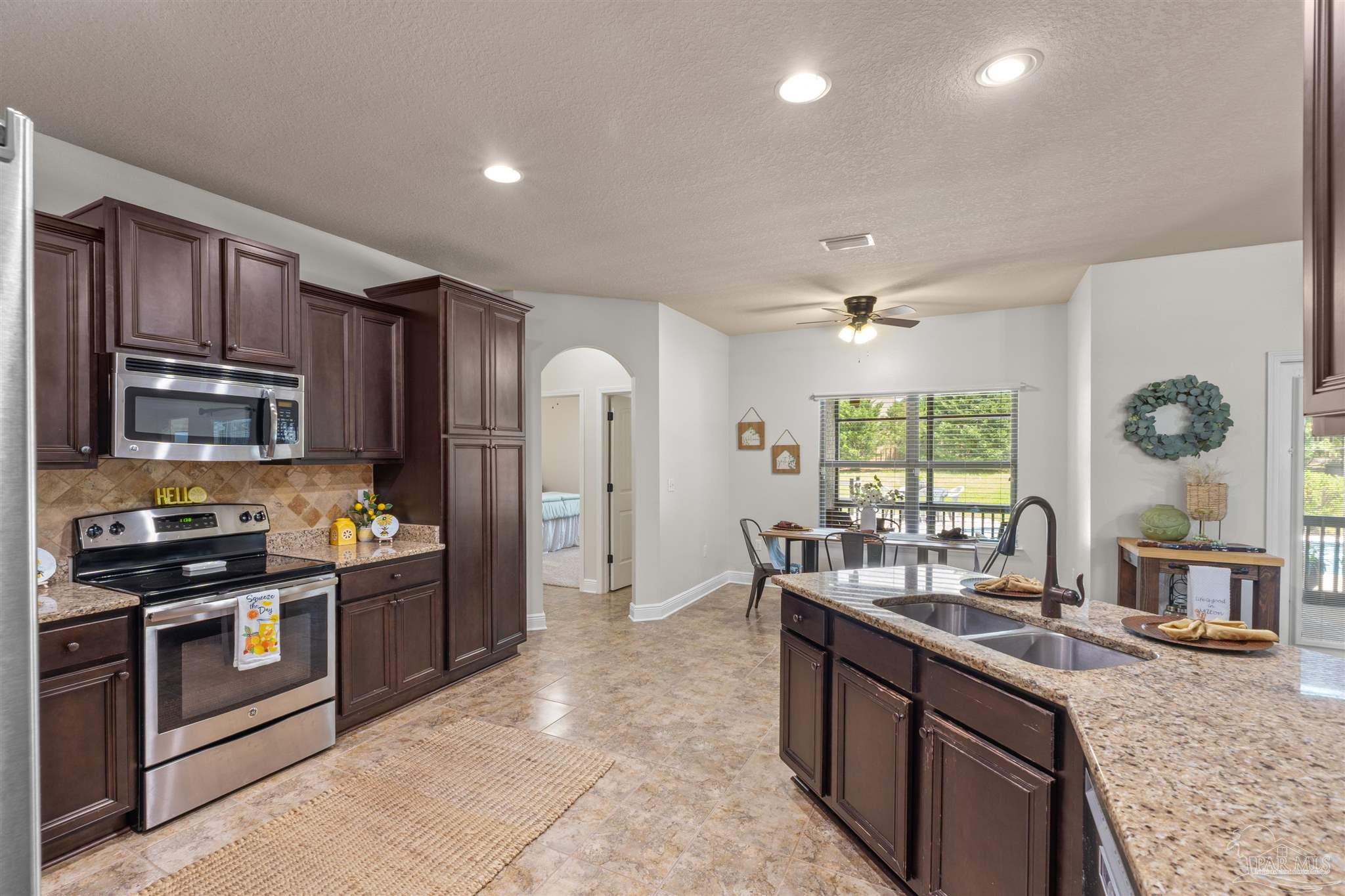 2698 Tulip Hill Road Pace, FL 32571 - Photo 24 of 65 a kitchen with stainless steel appliances granite countertop a stove and a sink