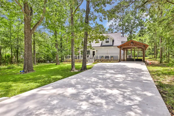 a front view of a house with a yard and large trees