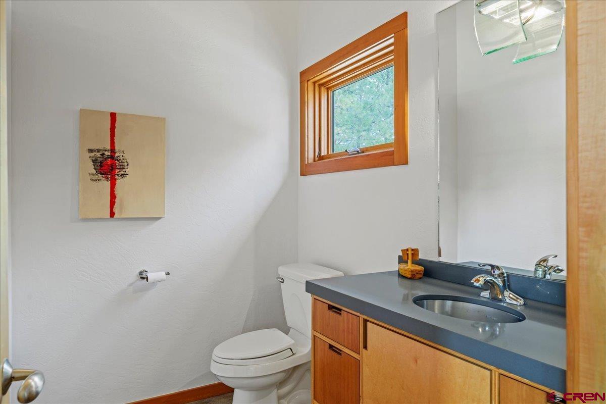 412 South Badger Trail Ridgway, CO 81432 - Photo 12 of 45 a bathroom with a granite countertop sink a toilet and a mirror