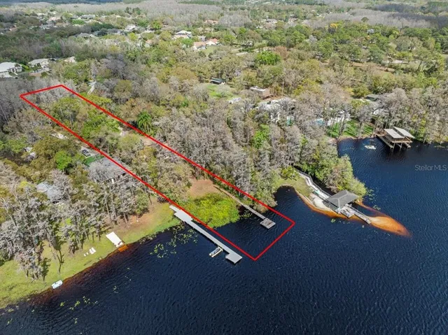 an aerial view of a house a yard and lake view
