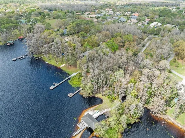 an aerial view of a house a yard and mountain view in back