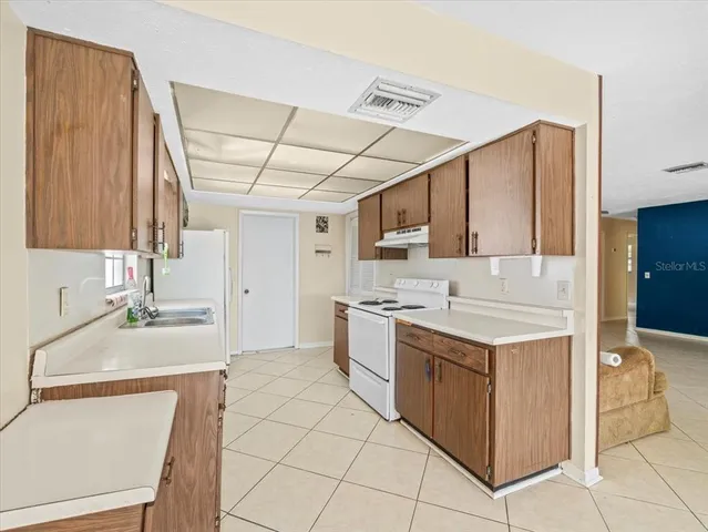 a kitchen with a stove sink and cabinets
