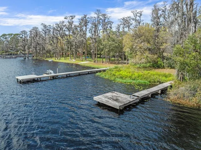 a view of a wooden deck with chairs and a lake view