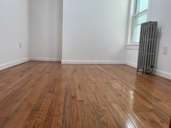 142 Shaw Street Lowell, MA 01851 - Photo 12 of 31 a view of an empty room with wooden floor and a window
