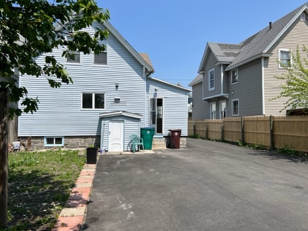 142 Shaw Street Lowell, MA 01851 - Photo 2 of 31 a view of a house with a yard and garage