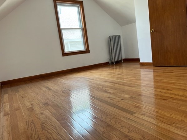 142 Shaw Street Lowell, MA 01851 - Photo 21 of 31 a view of an empty room with wooden floor and a window