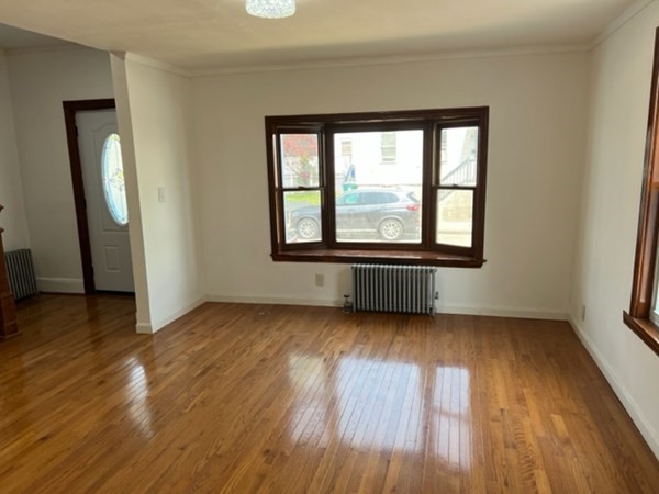 142 Shaw Street Lowell, MA 01851 - Photo 4 of 31 an empty room with wooden floor and windows
