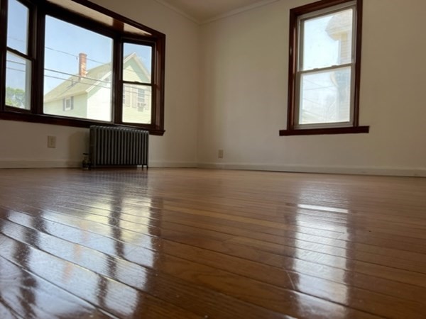 142 Shaw Street Lowell, MA 01851 - Photo 5 of 31 an empty room with wooden floor and windows