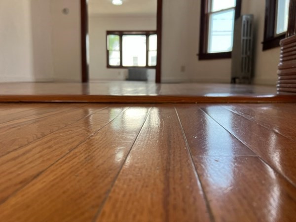 142 Shaw Street Lowell, MA 01851 - Photo 6 of 31 a view of an empty room with wooden floor and a window