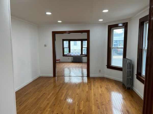 142 Shaw Street Lowell, MA 01851 - Photo 7 of 31 wooden floor in an empty room with a window