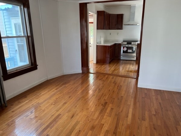 142 Shaw Street Lowell, MA 01851 - Photo 9 of 31 a view of an empty room with wooden floor and a window