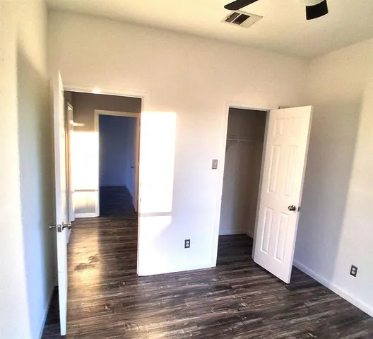 an empty room with wooden floor and closet