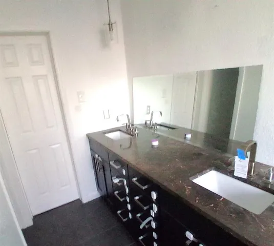 a bathroom with a granite countertop sink a mirror and vanity