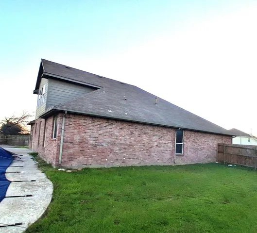 a view of a backyard with plants and wooden fence