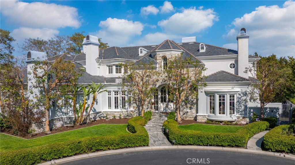a front view of a house with a garden and plants