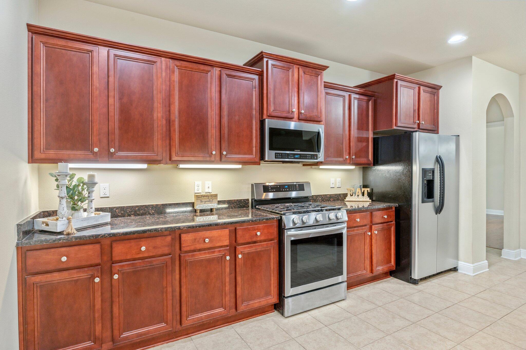 615 Red Fern Road Crestview, FL 32536 - Photo 14 of 33 a kitchen with stainless steel appliances granite countertop a stove top oven a refrigerator and a sink