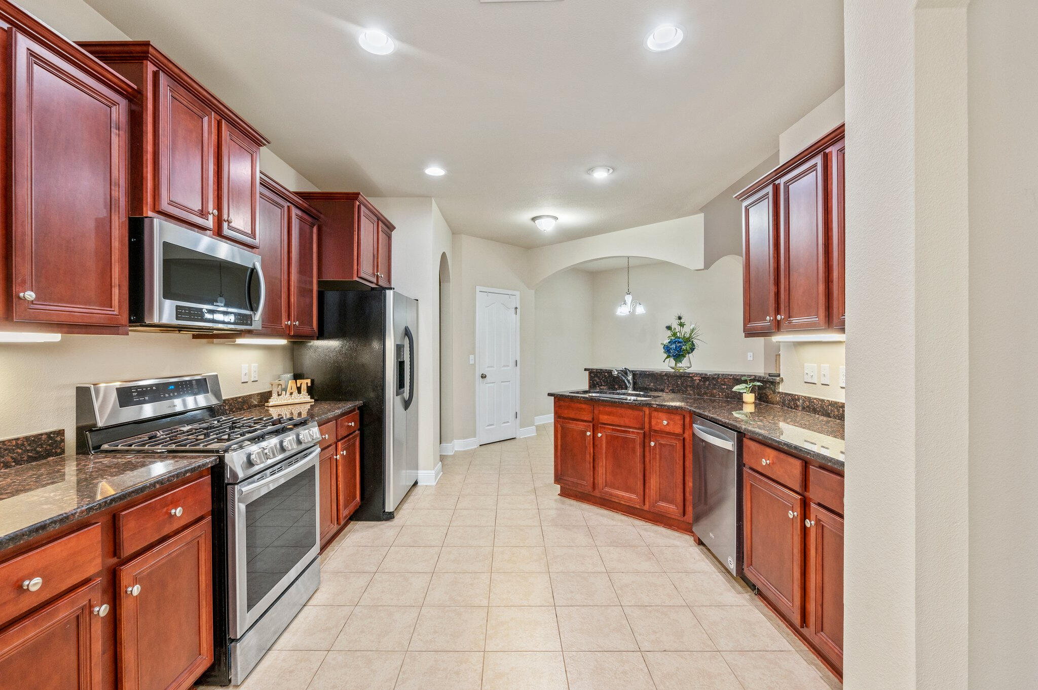 615 Red Fern Road Crestview, FL 32536 - Photo 18 of 33 a large kitchen with stainless steel appliances granite countertop a stove top oven a sink dishwasher a refrigerator and a microwave