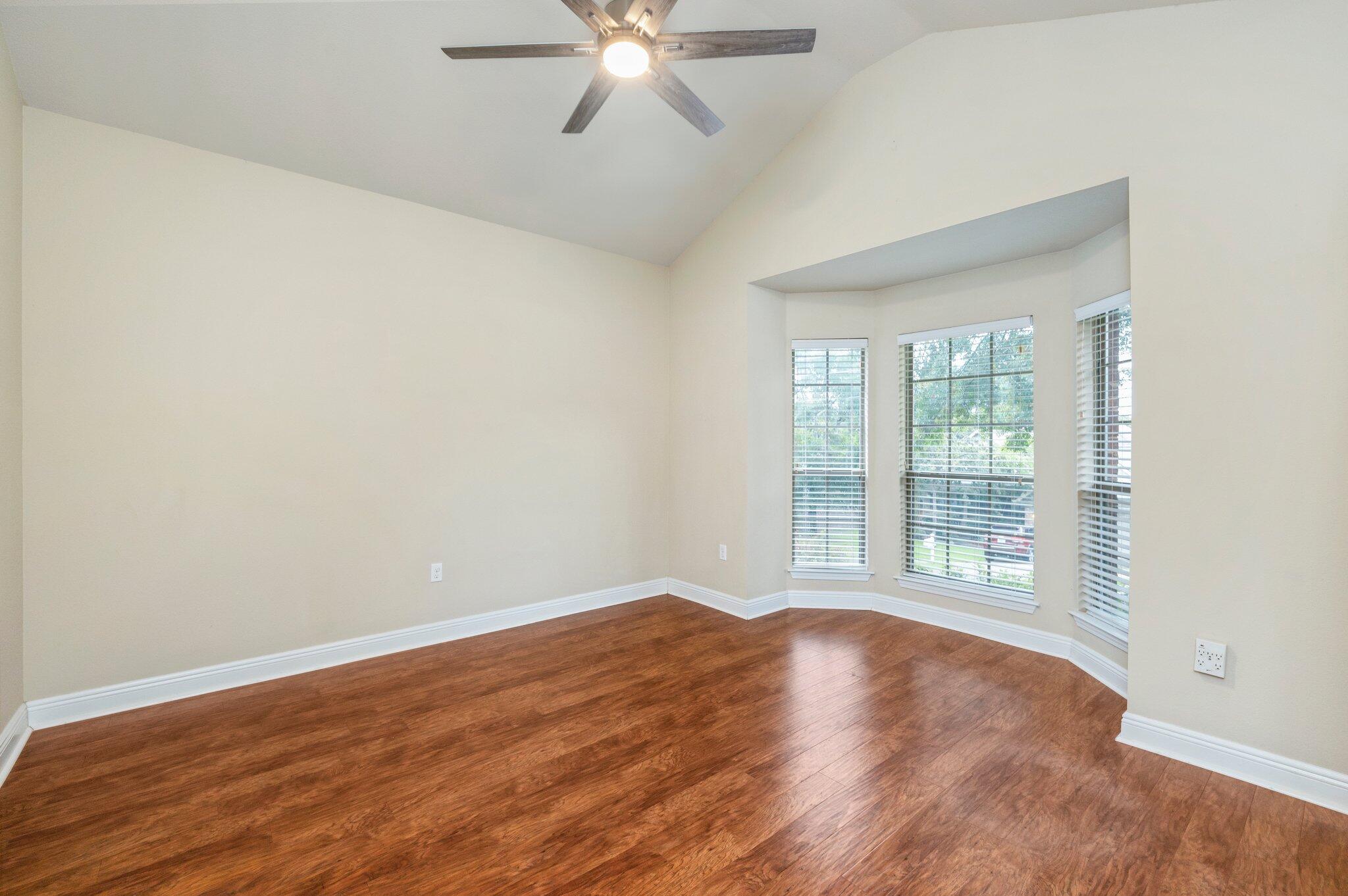 615 Red Fern Road Crestview, FL 32536 - Photo 7 of 33 an empty room with wooden floor fan and windows