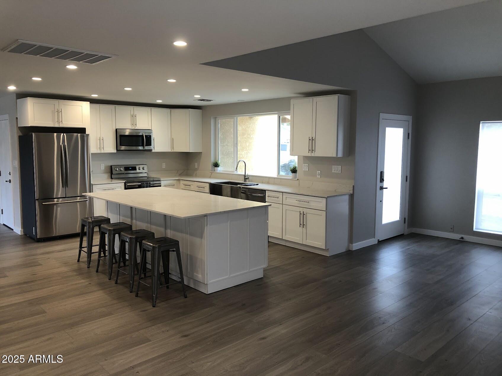 4910 East Charter Oak Road Scottsdale, AZ 85254 - Photo 1 of 2 a kitchen with stainless steel appliances granite countertop a table chairs a sink dishwasher a refrigerator and a stove with wooden floor