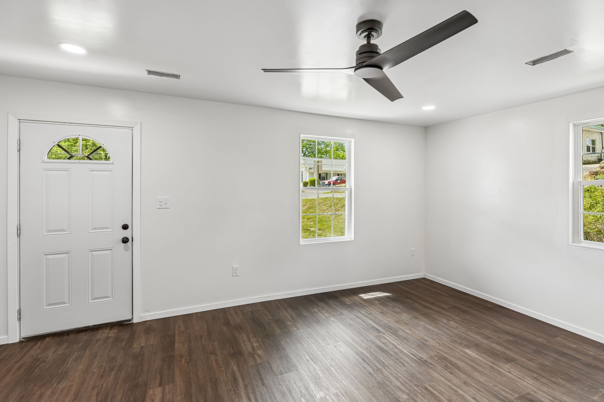 330 West Washington Street Pulaski, TN 38478 - Photo 5 of 36 an empty room with wooden floor ceiling fan and windows