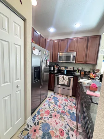 a kitchen with stainless steel appliances granite countertop a refrigerator and a stove top oven