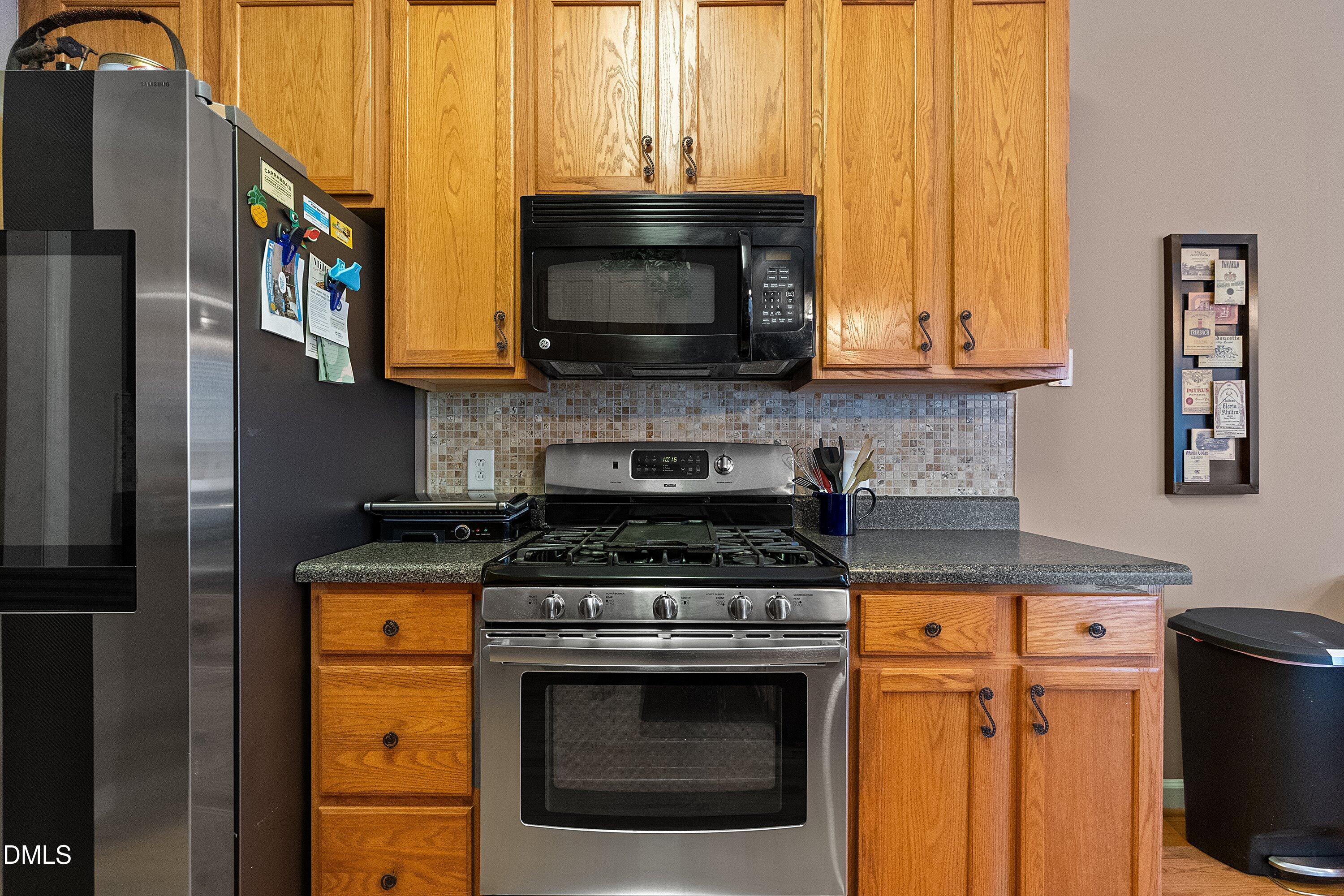 1916 Spanish Bay Court Raleigh, NC 27604 - Photo 18 of 63 a kitchen with stainless steel appliances granite countertop a stove a sink and a microwave