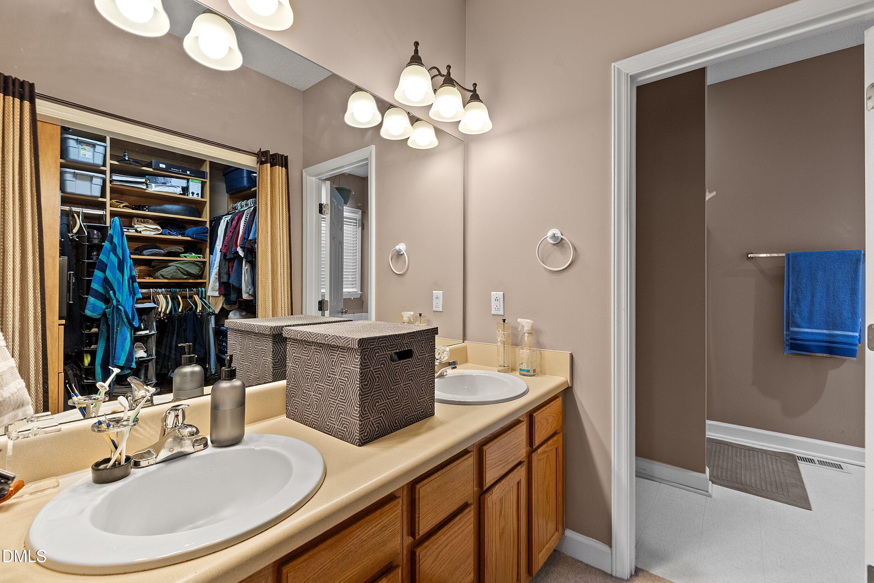 1916 Spanish Bay Court Raleigh, NC 27604 - Photo 23 of 63 a bathroom with a double vanity sink a mirror and a shower