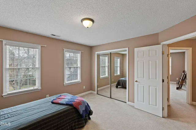 an empty room with chandelier fan and windows