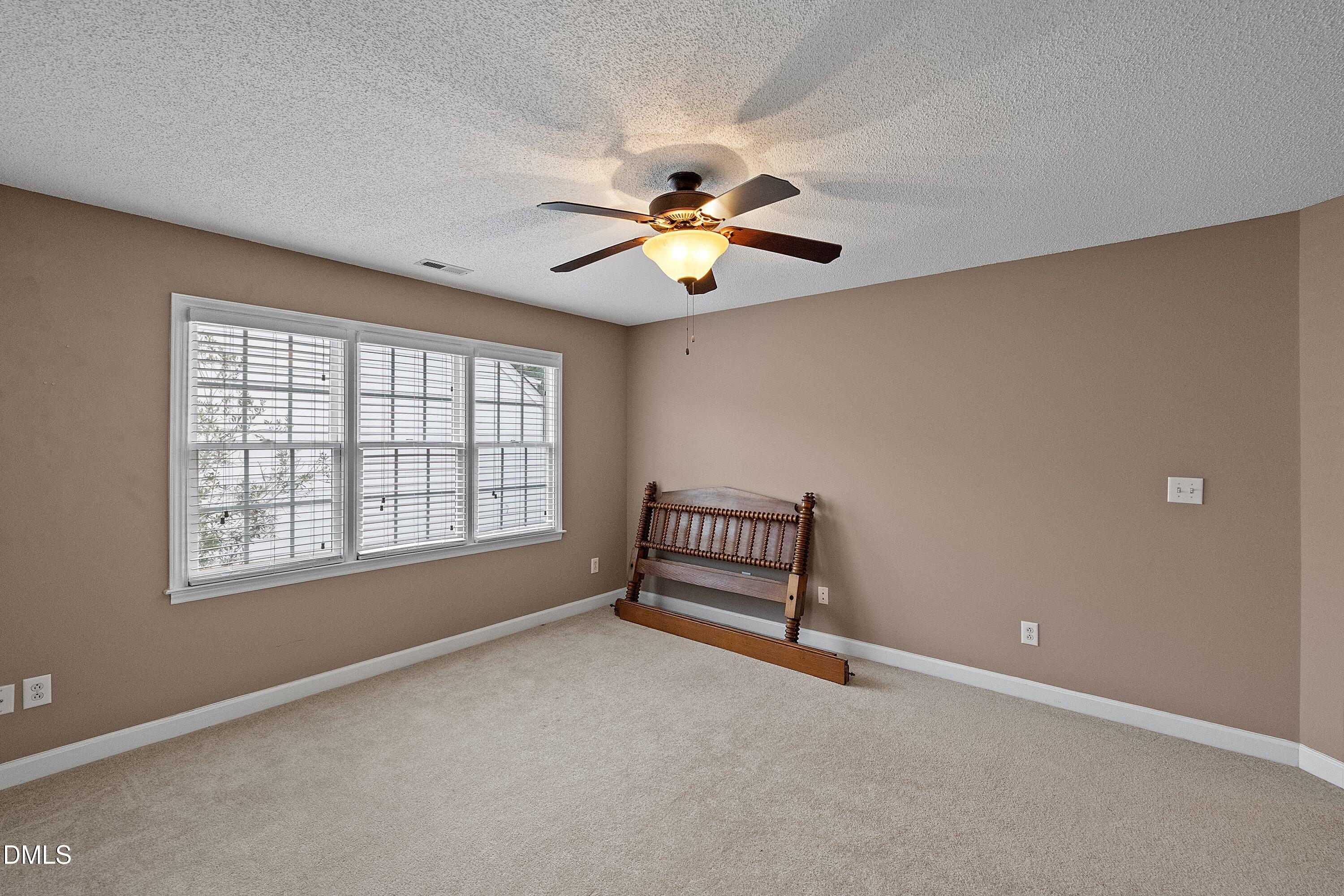 1916 Spanish Bay Court Raleigh, NC 27604 - Photo 34 of 63 a bed room with a window and a ceiling fan
