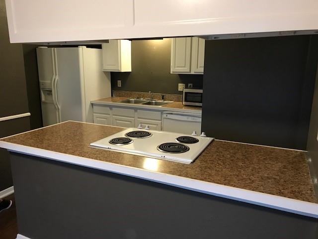4023 William Street Sachse, TX 75048 - Photo 32 of 36 Kitchen with white cabinetry, white appliances, and dark countertops