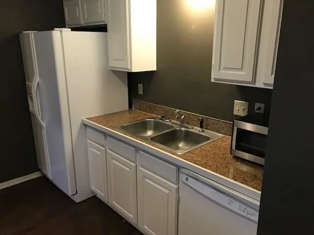 a sink with white cabinets