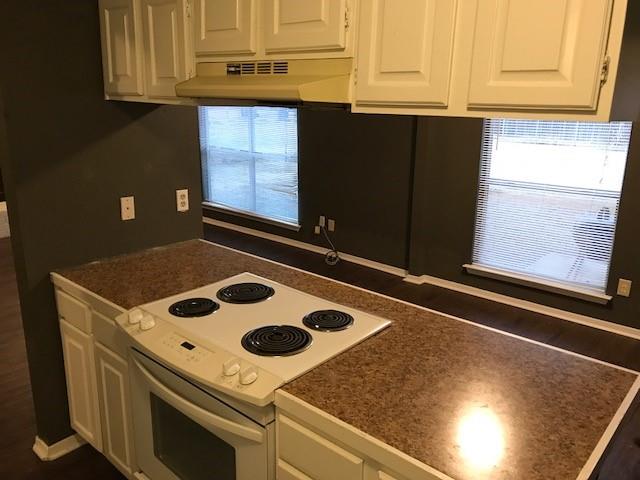 4023 William Street Sachse, TX 75048 - Photo 34 of 36 Kitchen with white cabinetry, electric range, dark countertops, and under cabinet range hood