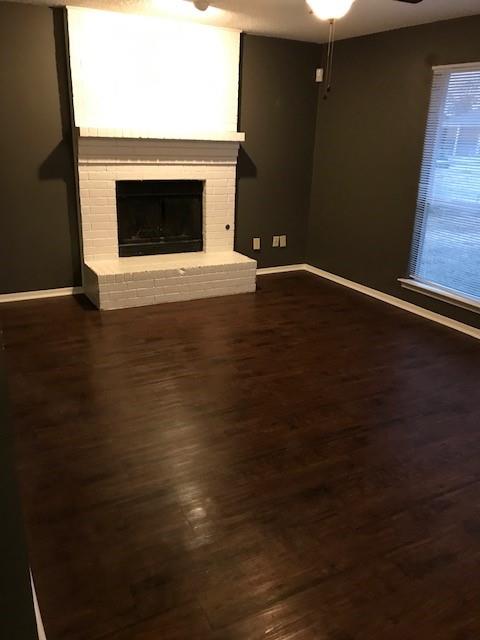 4023 William Street Sachse, TX 75048 - Photo 36 of 36 Unfurnished living room featuring a fireplace, ceiling fan, and dark wood-type flooring